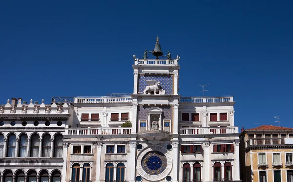 Norditalien, Venedig, Uhrenturm der St. Mark, St. Mark 's Square, geschmückt mit der Skulptur geflügelter Löwen auf dem Hintergrund des blauen Himmels — Stockfoto