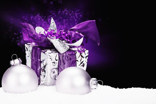 Purple christmas present in snow — Stock Photo, Image