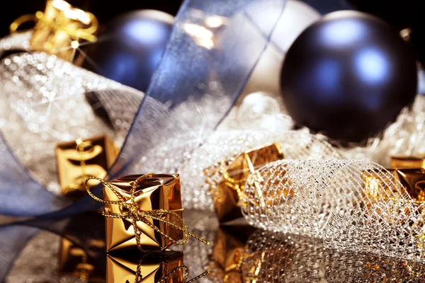 Mały złoty Boże Narodzenie obecny przed świątecznych dekoracji — Zdjęcie stockowe