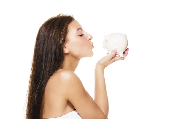 Mooie brunette vrouw zoenen een piggy bank — Stockfoto
