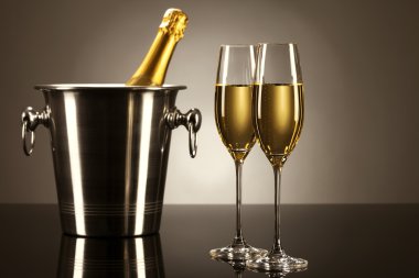 Two glasses of champagne with a champagne bottle in a bucket clipart
