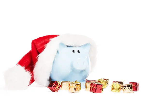 Piggy Bank portant santas chapeau avec des cadeaux de Noël minuscules — Photo