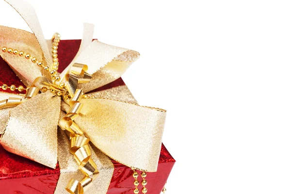 Closeup της ένα κόκκινο χριστουγεννιάτικο δώρο με χρυσές κορδέλες — Φωτογραφία Αρχείου