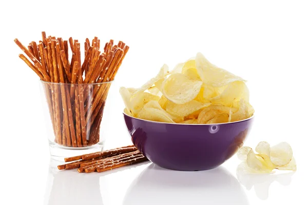 Patatas fritas en un tazón con palitos de pretzel en un vaso — Foto de Stock