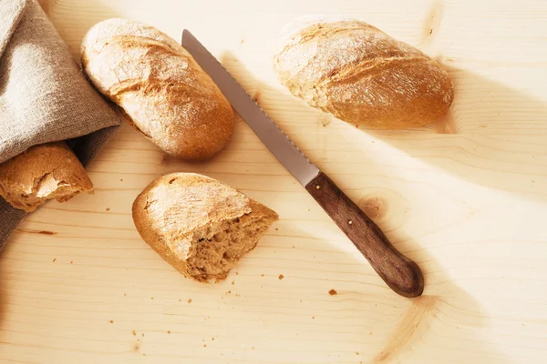 Roggenbrötchen von oben mit einem Leinentuch und einem Messer — Stockfoto