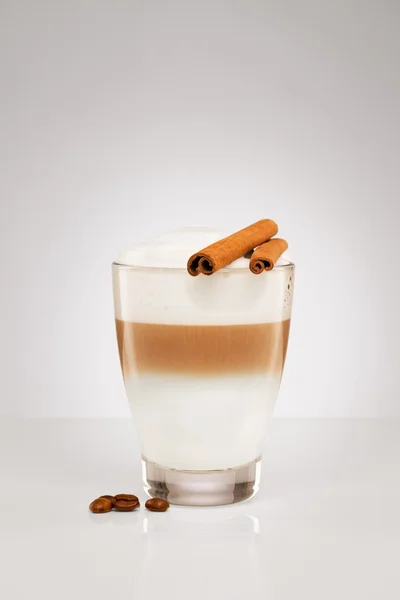 Latte macchiato with cinnamon sticks — Stock Photo, Image