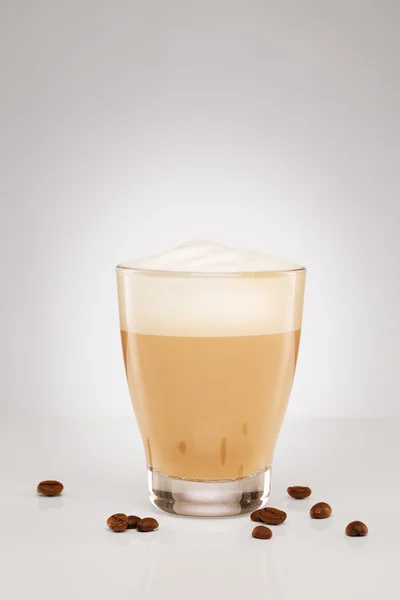 Cappuccino i ett litet glas med kaffebönor — Stockfoto