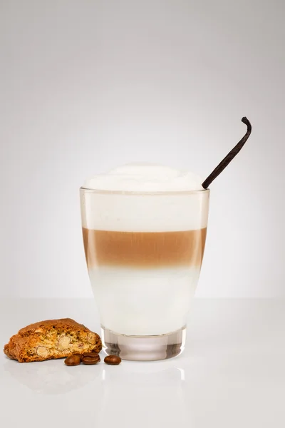 Pequeno macchiato de latte com um feijão de baunilha e um biscoito — Fotografia de Stock