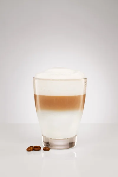 Liten latte macchiato med kaffebönor — Stockfoto