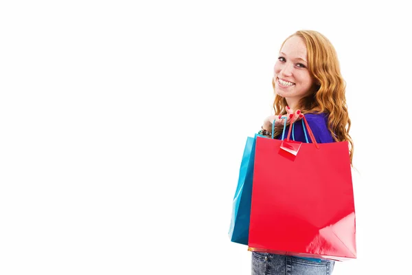 Happy young redhead woman with shopping bags — Stock Photo, Image