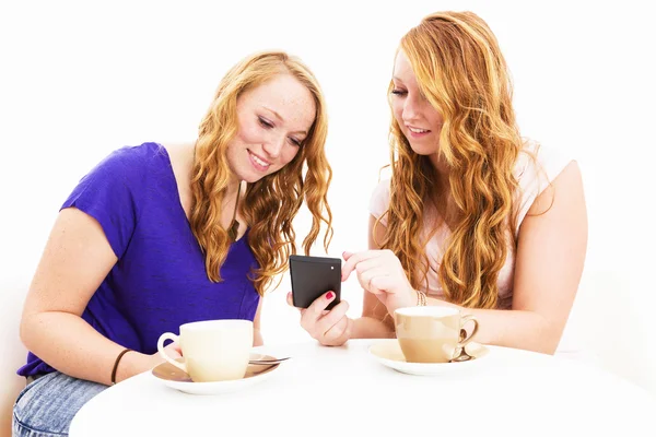 Zwei Frauen mit einem Smartphone beschäftigt — Stockfoto