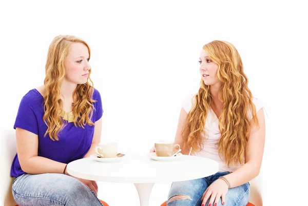 Mulheres sérias conversando sentadas em uma mesa de café — Fotografia de Stock