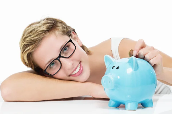 Lachende vrouw gooien geld in haar spaarpot — Stockfoto