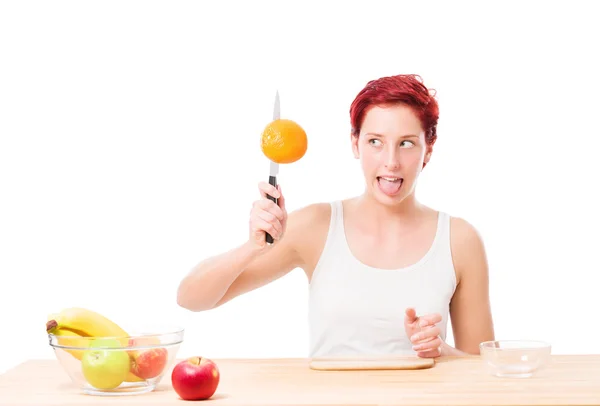 Mulher engraçada tentando cortar uma laranja — Fotografia de Stock