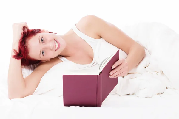 Happy in bed reading a book — Stock Photo, Image