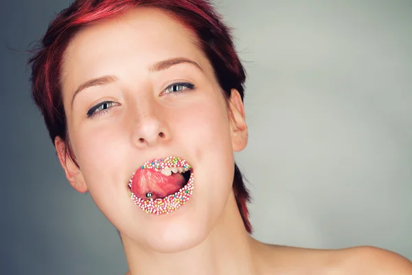 Mujer lamiendo sus coloridos labios de azúcar —  Fotos de Stock