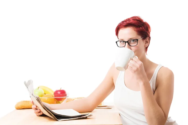 Young woman drinking coffee reading newspaper — Stock Photo, Image