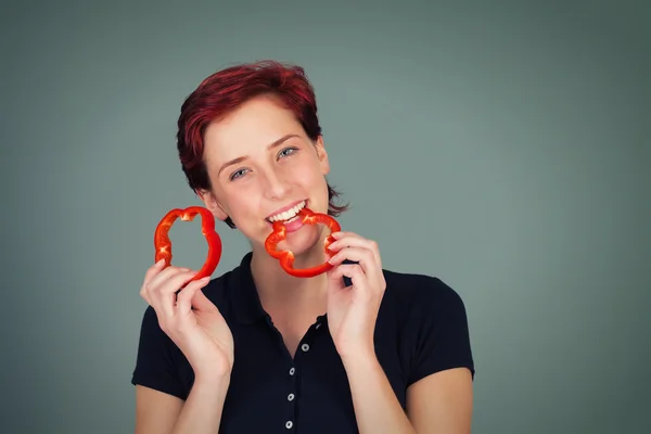 Gelukkige vrouw bijt in een segment van peper — Stockfoto