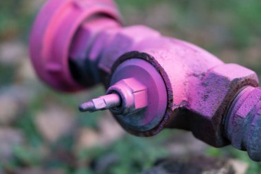 Bulanık arkaplanda eski pembe metal borunun yakın çekim görüntüsü 
