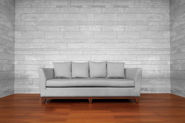 Silla de sofá gris sobre suelo de madera marrón y pared blanca — Foto de Stock