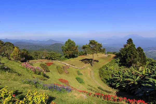 Villaggio di montagna con giardino fiorito in cielo blu brillante — Foto Stock