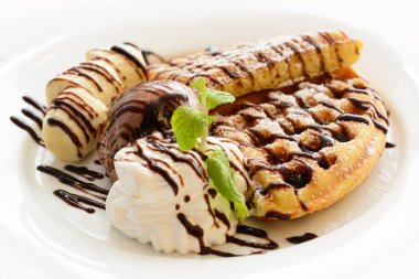 Çikolatalı muzlu waffle beyaz plaka üzerinde