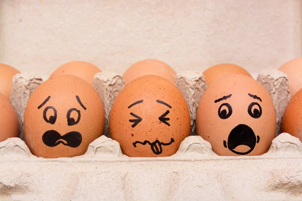Ovos de cara de pânico em caixa de papel marrom — Fotografia de Stock