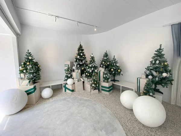 Beyaz oturma odasında süslemeleri ve hediye kutuları olan güzel bir Noel ağacı.