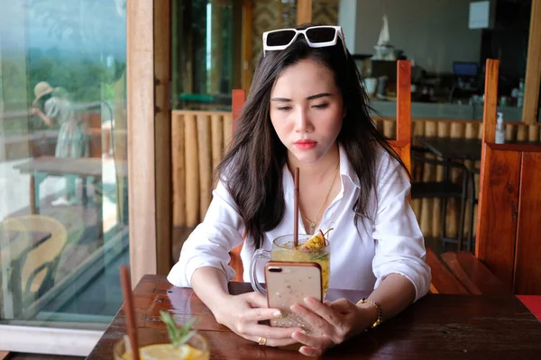 Asijské Mladá Žena Pomocí Telefonu Pít Vášeň Ovocný Džus Kavárně — Stock fotografie