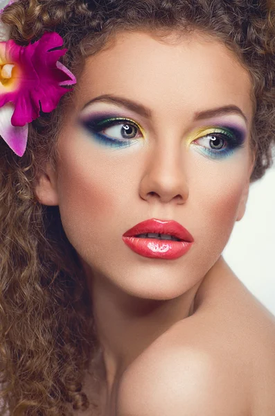 Vrouw met bloemen in haar en make-up — Stockfoto