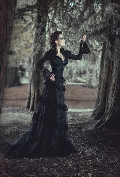 Femme en forêt en robe noire — Photo