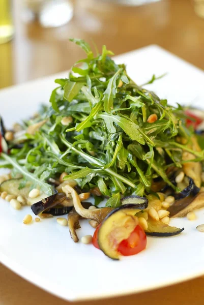 Salada de Arugula com cogumelos de ostra, tomates, berinjela e pinhões — Fotografia de Stock