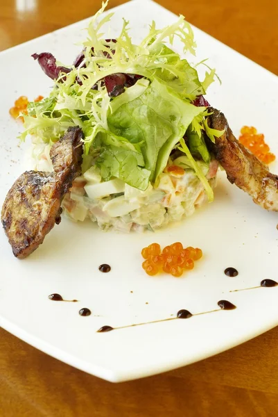 Traditional Russian salad with grilled quail and red caviar — Stock Photo, Image
