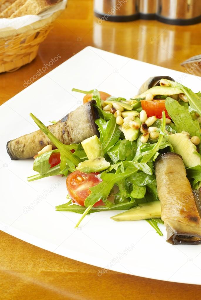 Fresh salad with eggplant rolls, avocado and nuts