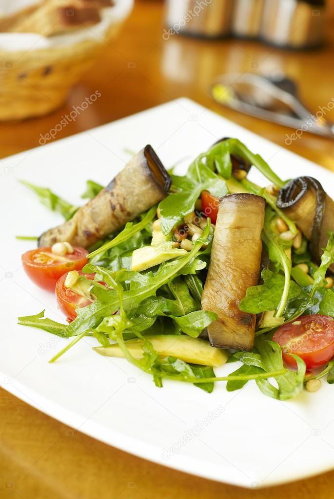Fresh salad with eggplant rolls, avocado and nuts