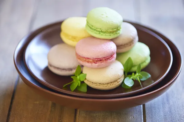 Colorful macaroons on brown plate — Stock Photo, Image