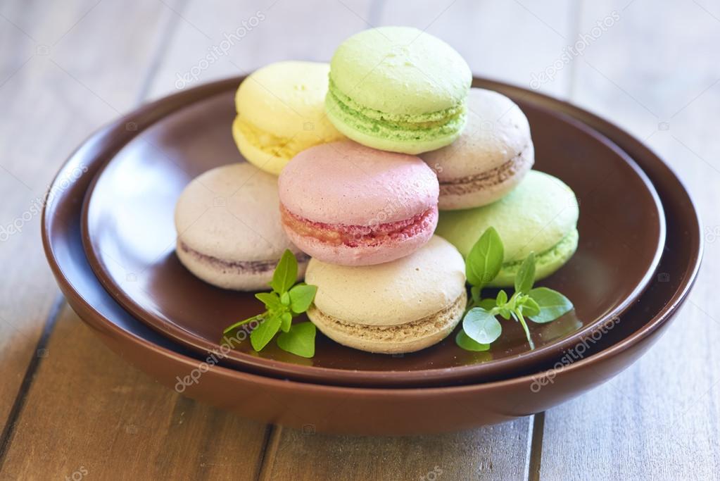 Colorful macaroons on brown plate