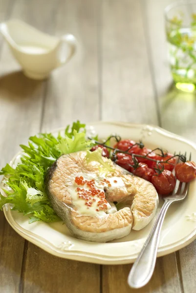 Gebakken zalm met rode kaviaar saus, cherry tomaten en verse salade — Stockfoto