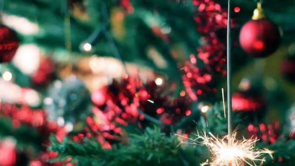 Kerstboom met kleur ballen en brandende sparkler — Stockvideo