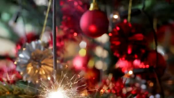 Kerstboom met kleur ballen en brandende sparkler — Stockvideo