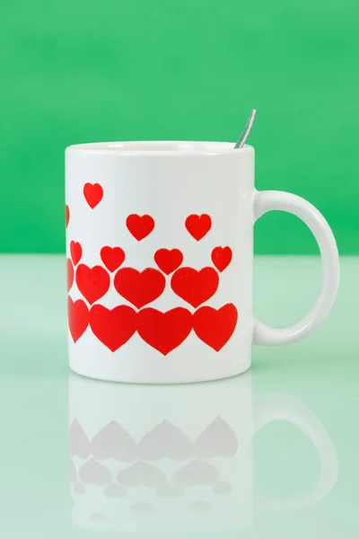 White cup with red hearts — Stock Photo, Image