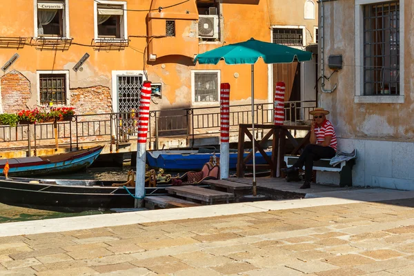 16. Jul 2012 - Gondolier waiting for tourists at canal in Venice, Italy — Stock Photo, Image