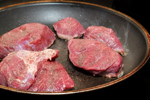 Beef meat on pan with pepper and sea salt — Stock Photo, Image