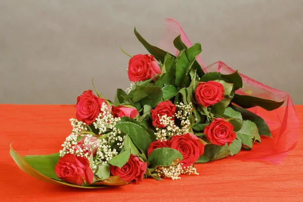 Μπουκέτο με φρέσκα κόκκινα τριαντάφυλλα σε γκρι — Φωτογραφία Αρχείου
