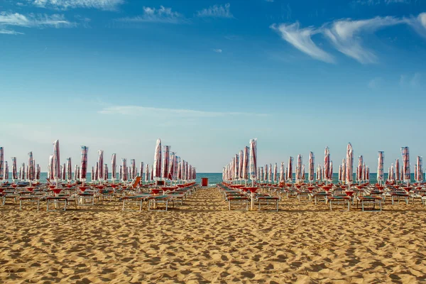 Withdrawn umbrellas and sunlongers on the sandy beach — Stock Photo, Image