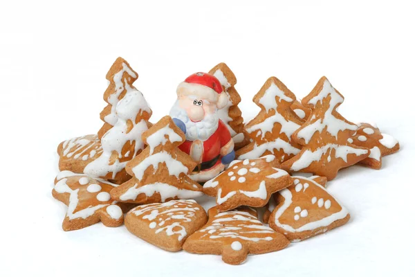 Panes de jengibre navideños y santa cerámica sobre fondo blanco — Foto de Stock