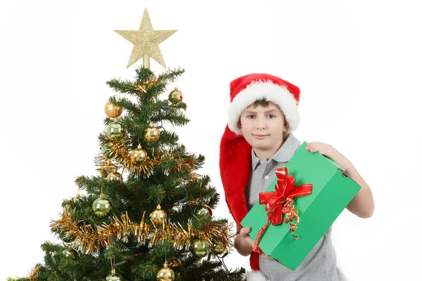 Щасливий хлопчик у капелюсі Санта показує різдвяний подарунок — стокове фото