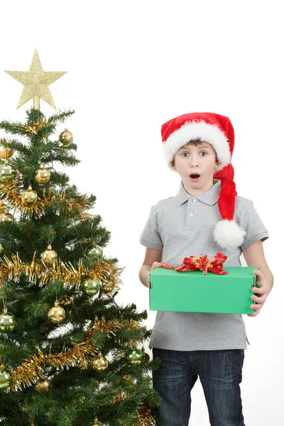 Lycklig pojke i santa hatt överraskad av julklapp — Stockfoto