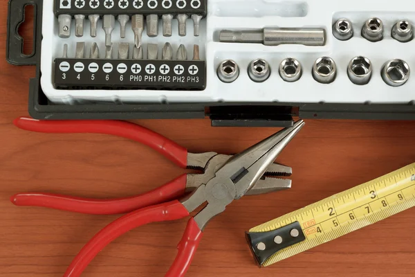 Caixa de ferramentas de chave de fenda com conjunto de bits, alicates e fita métrica — Fotografia de Stock