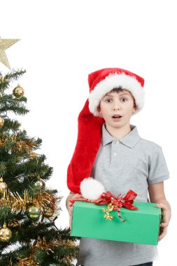 Happy boy in santa hat surprised by christmas present
